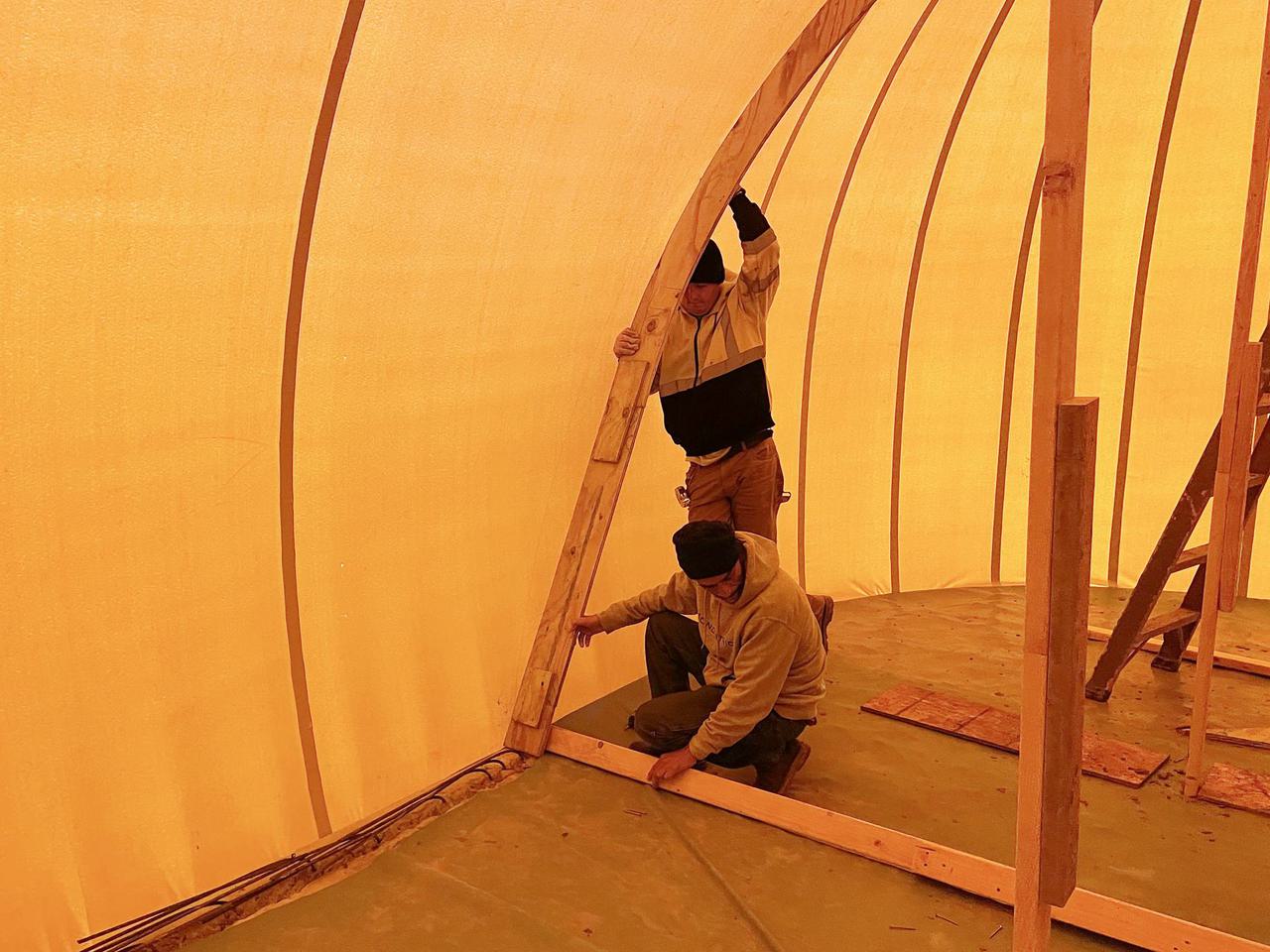 Crews install augment frames inside the inflated Airform to create gothic arches.