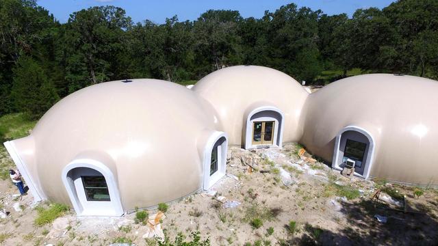 A Monolithic Dome home with windows and doors set inside extended augments.